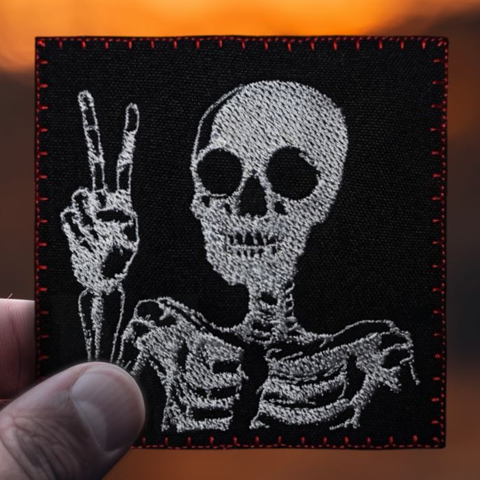 skeleton patch with victory gesture on fire background